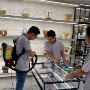 IK Services two specialist cleaning a glass display case in a store